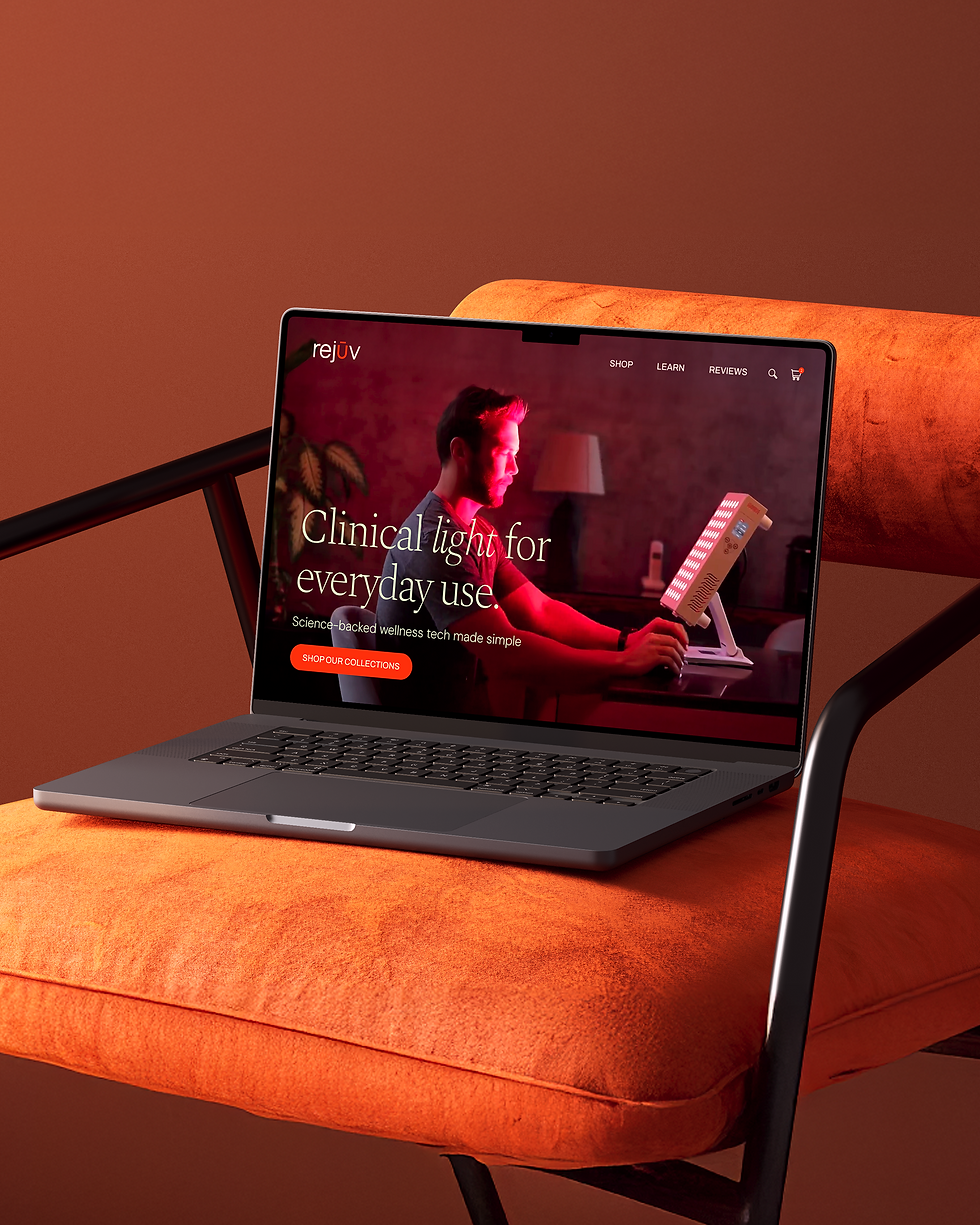 A laptop on an orange armchair displaying the Rejuv website.