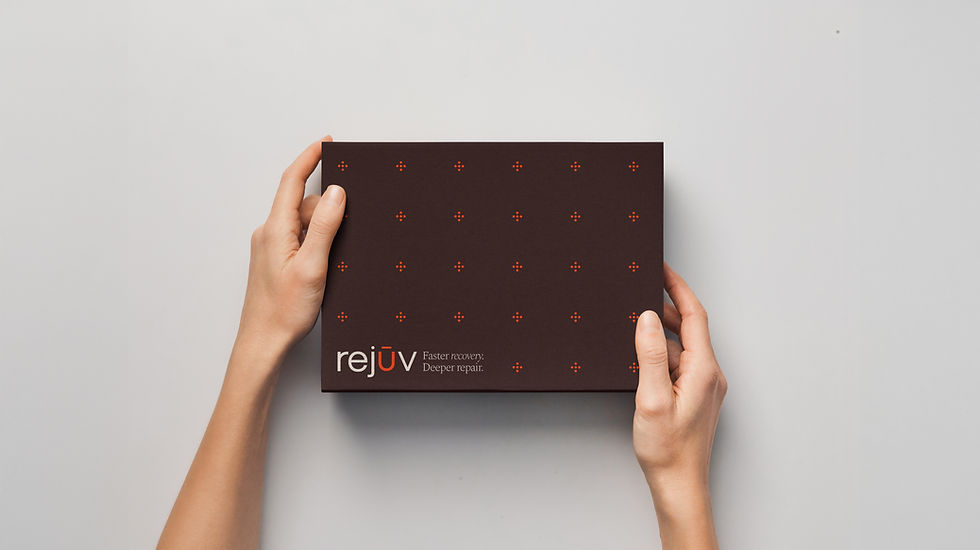 Hands holding a deep burgundy Rejuv box patterned with the orange emblem and the tagline "Faster recovery. Deeper repair."