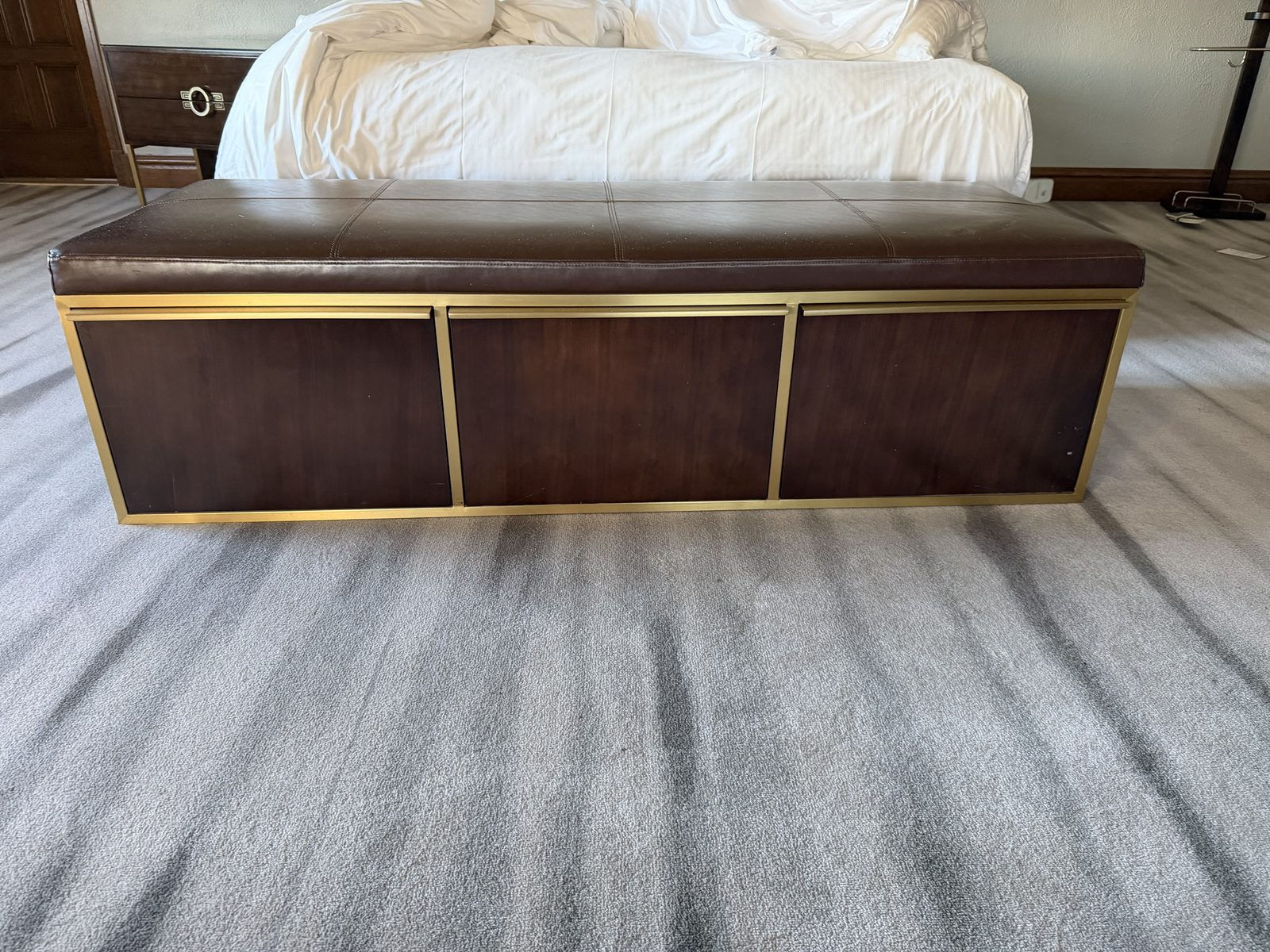 Storage bench with leather-look top and brass trim, drawers closed