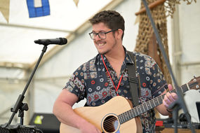Ben Foulds Playing Guitar and Singing at a Festival