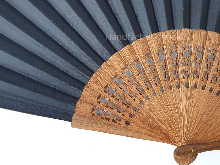 Thumbnail: Spanischer Handfächer "Granada" mit Durchbrüchen und Bespannung in Stoff in Schwarz. Detail von Holz