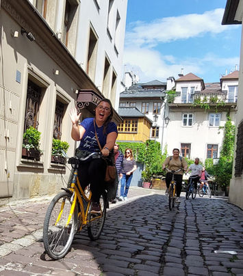 Happy woman on a bike tour Poland on a cobblestone street