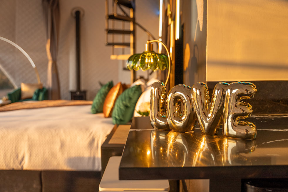 gold love balloons on a table in a bedroom
