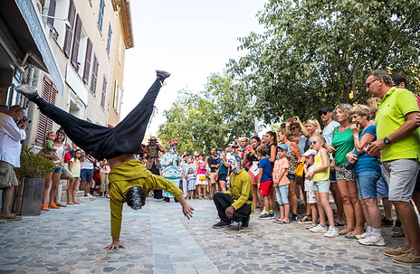 Deux acrobates réalisant une performance spectaculaire devant une foule attentive et admirative