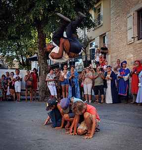 Acrobate réalisant un saut spectaculaire au-dessus du public lors d’une fête médiévale à Villeneuve d’Aveyron