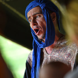 Photo d'un conteur en train de raconter des contes berbères dans le campement berbère