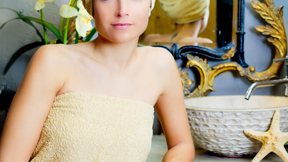Woman in towel after shower preparing for daily body care routine including magnesium lotion