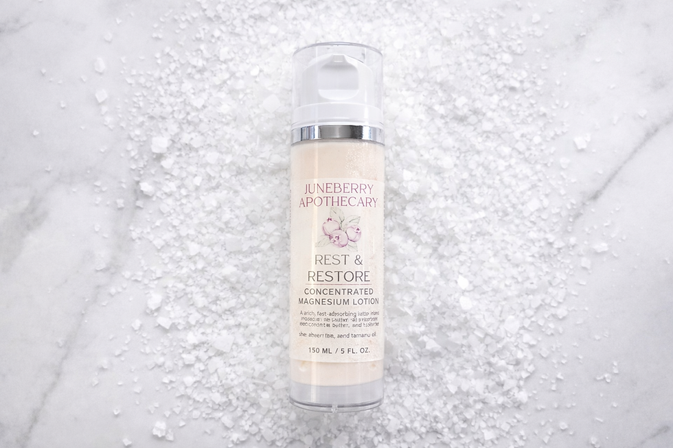 Thumbnail: Juneberry Apothecary Rest & Restore Magnesium lotion bottle centered on a bed of coarse magnesium salt crystals.