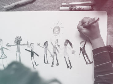 child drawing a picture of people