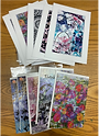 Collection of colorful art prints and paper goods featuring original mixed media artwork