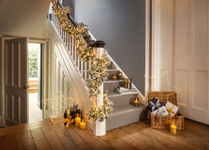 staircase decorated for christmas with wreath and fairy lights