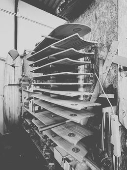 workshop rack filled with handcrafted wooden surfboards