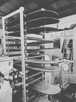 workshop rack filled with wooden surfboards