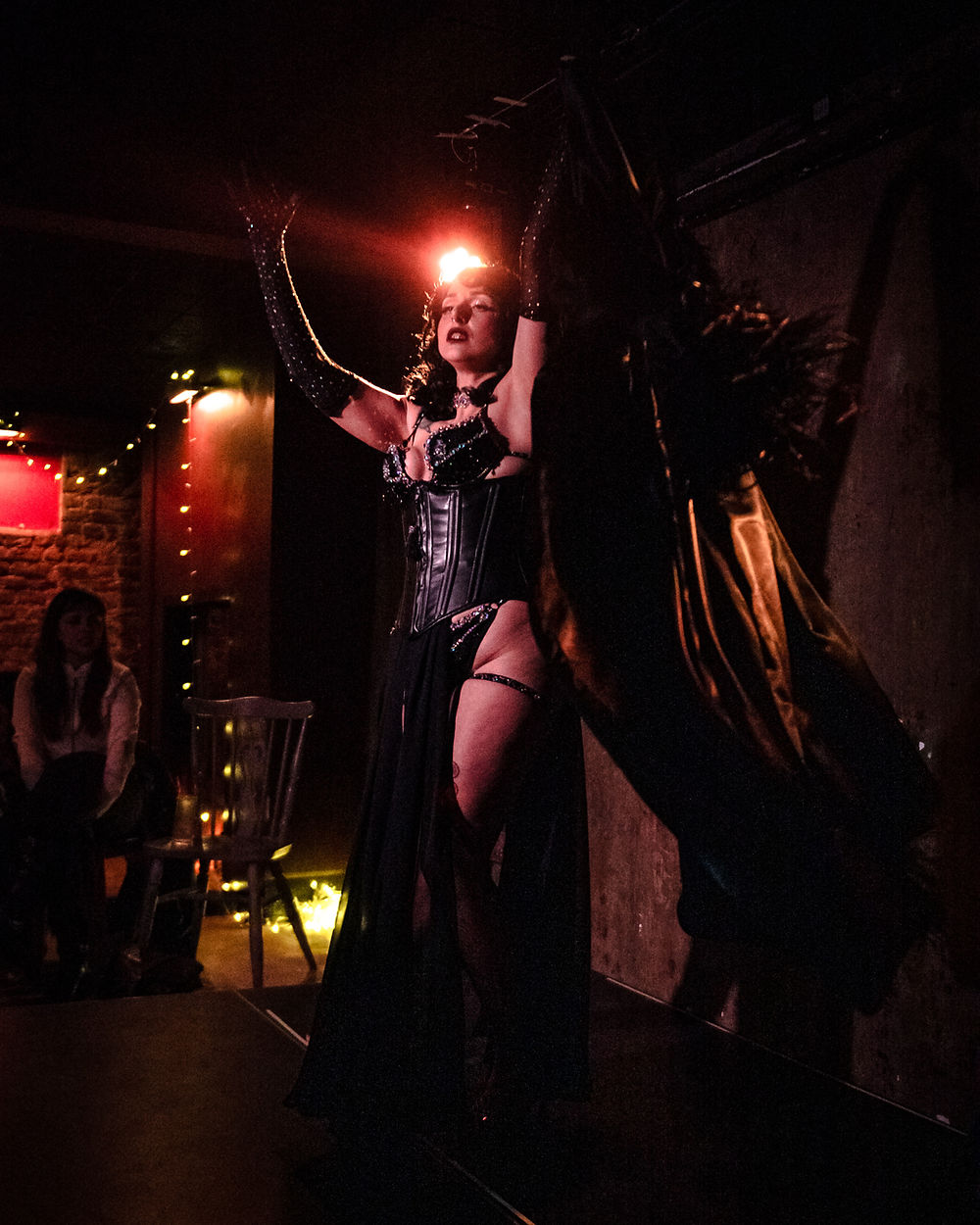 Performer in dark costume with glowing headdress