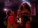 Burlesque performer in corset on stage with audience member