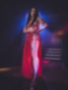 Woman in red harness and skirt with tattoos on stage