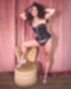 Performer in black corset and curly hair posing