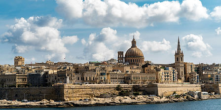 A stunning panoramic view of a historic European city skyline bathed in golden hour light.