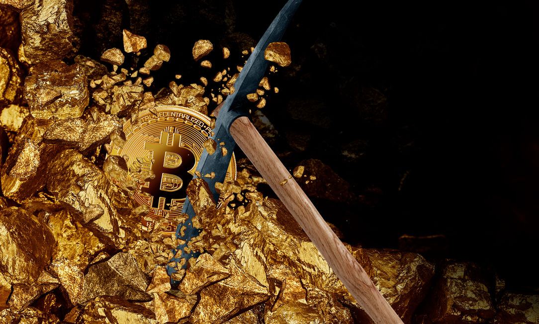 A pick axe chipping into golden bitcoin