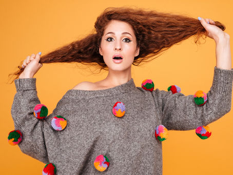 A woman pulling her curly red hair out on either side
