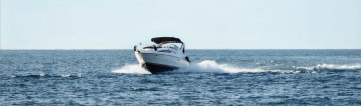 A well maintained boat being driven on the open water.