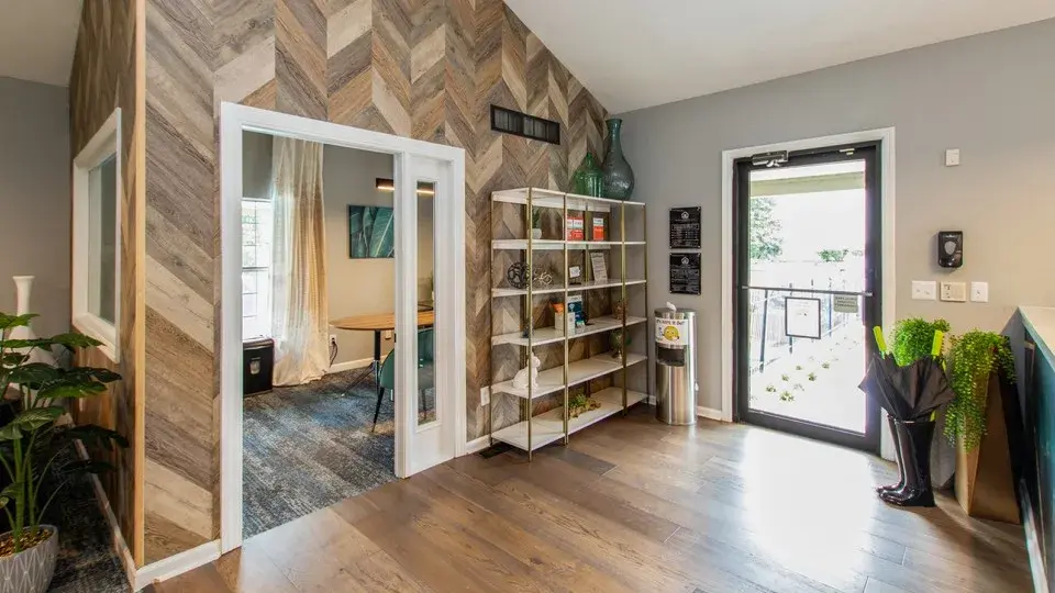 Sofa, couch, floor lamp, lamp, smoking chair, recliner, chair, rug, carpet, hardwood floor, window, window treatment, plant, natural light, light fixture, chandelier fireplace, painted brick, accent wall, time, coffee table, side table, arm chair, games, gameroom, recreation room