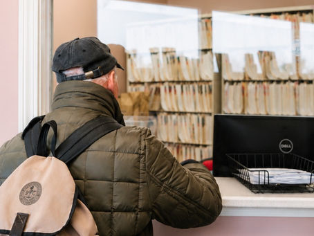 Patient checking in at a primary care clinic reception desk in Lynn, Massachusetts.