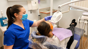 Dental professional performing an in-office teeth whitening procedure using a professional LED whitening light.