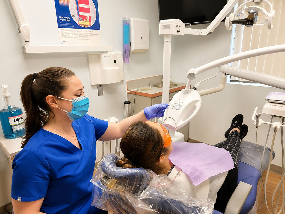 Dental professional performing an in-office teeth whitening procedure using a professional LED whitening light.