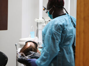 Dental hygienist performing a professional teeth cleaning to remove plaque at Avalon Dental Center in Cambridge, MA.