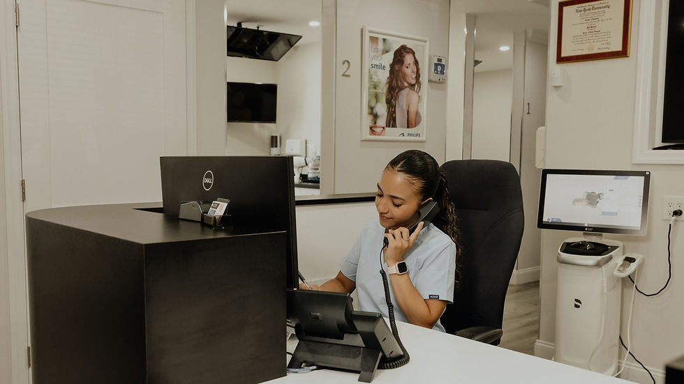Dental office team member helping patients schedule care before year-end dental insurance benefits reset.