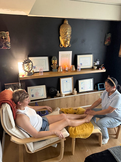 Nidtaya giving a client a Thai foot massage in the treatment room
