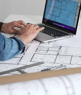 Architect drawing and measuring blueprints on a desk, creating detailed floor plans and de