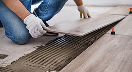 Laying tiles concept Tiler, spatula and glue when laying tiles with close up hands Pull ta