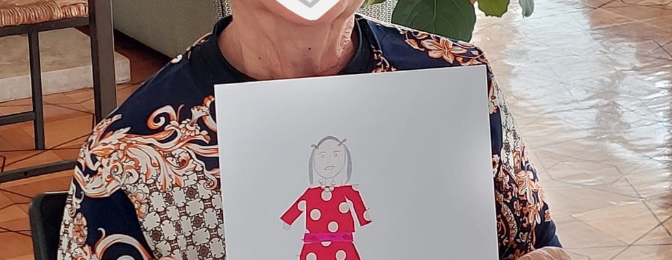 Idosa segurando desenho que ela fez na atividade