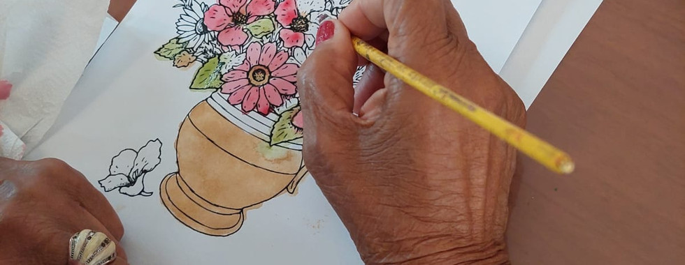 Idosa pintando flores com pigmentos naturais