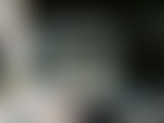 An outdoor wedding ceremony setup at Everett West in Portland featuring white chairs arranged on a patio beneath string lights, with two cascading floral installations of white orchids, baby’s breath, roses, and soft pastel blooms framing the ceremony space.