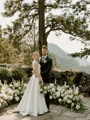 Bride and groom among flowers overlooking the columbia river gorge