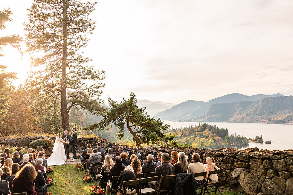 Bride and Groom saying their vows in front of family and friends as they enjoy the view of the sun setting in the Columbia River Gorge.
