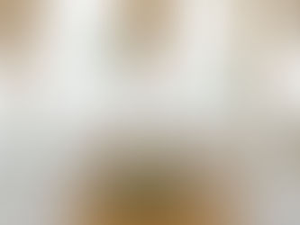 Sweetheart table topped with bud vases with a variety of white florals, a large white floral arrangement at the foot of the table, and a large circular gold arch with two more white floral arrangements attached behind the table.