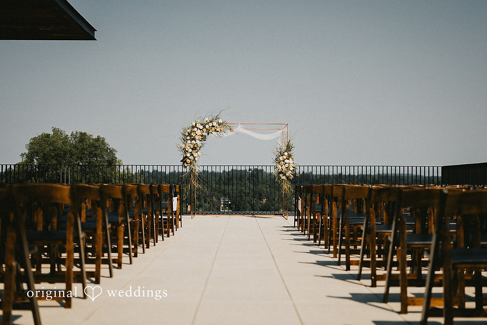 View of a ceremony space with dark wooden chairs and a gorgeous blush and white floral covered Chuppah.