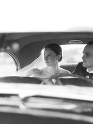 Bride and Groom seated in the back of a vintage car following a beautiful wedding.