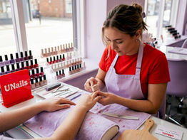 Nail technician repairing client's nails at salon