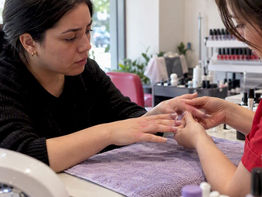 Technician examining irritated gel manicure fingertips