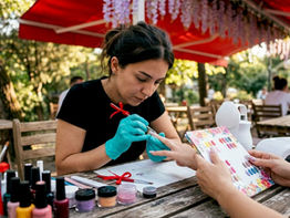Nail artist shaping textured gel nails in salon