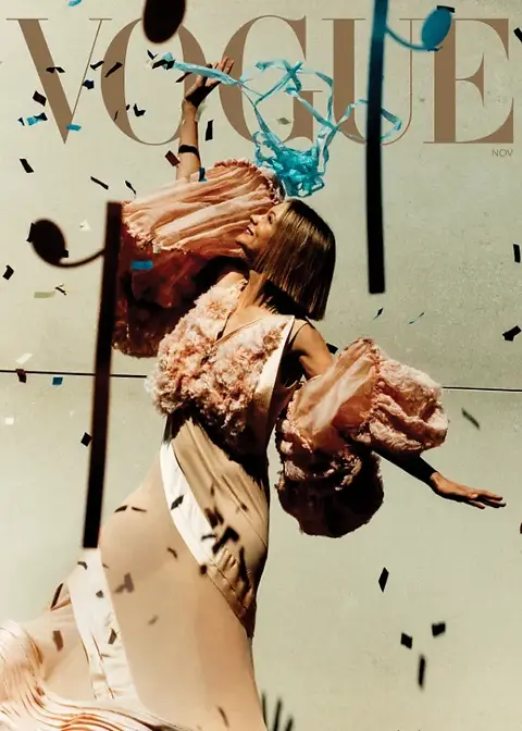 Editorial cover image featuring actor Carey Mulligan posing in a cream satin gown with pink textured sleeves, surrounded by flying confetti. The composition highlights elegance, movement, and high‑fashion artistry typical of Vogue’s distinctive style
