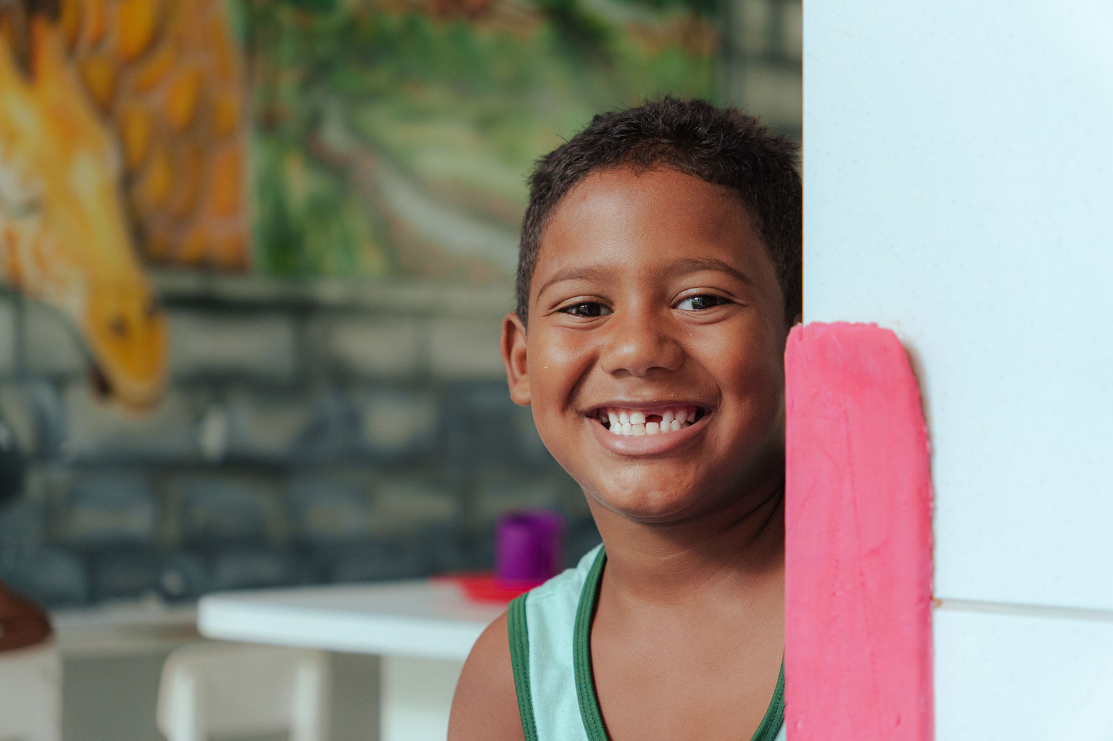 Menino sorrindo em uma das salas do Lar