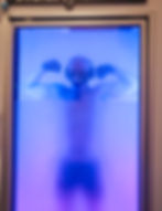 A man inside a cryotherapy chamber flexing his muscles.