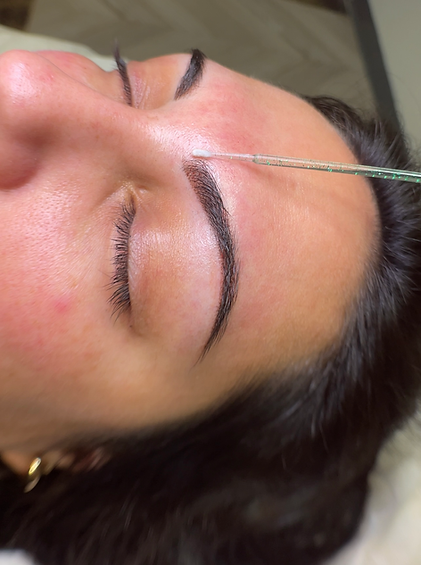 Threading eyebrows procedure on a woman's face at brow bar Services.
