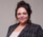 Smiling woman with her hair up wearing a tweed blazer